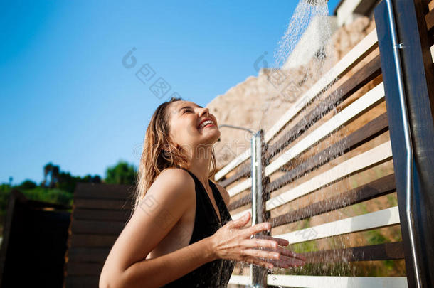 美丽的年轻女孩穿着泳装在海滩上洗澡