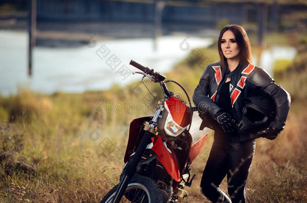 她摩托车旁边的女摩托车越野赛车手