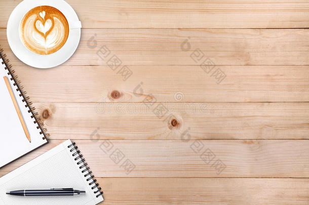 一本打开的空白<strong>笔记本</strong>，<strong>上面</strong>有铅笔和一杯木制的咖啡