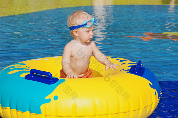 孩子日光浴，在游泳池里用充气玩具游泳