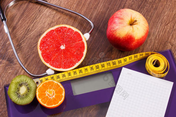 电子浴室秤，厘米和新鲜水果与听诊器，减肥和健康的生活方式