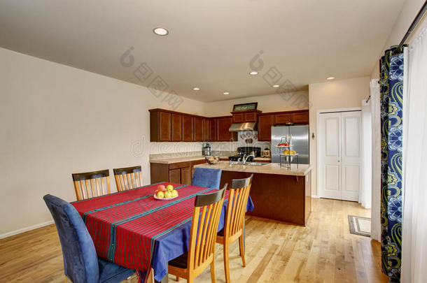明亮的厨房和餐厅内部有白色的墙壁和硬木地板。