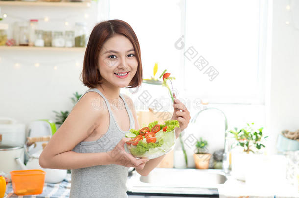 节食的概念。 健康的食物。 美丽的年轻亚洲女人吃新鲜蔬菜沙拉。 失去重量的概念