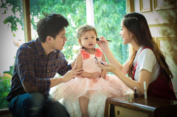 爸爸，妈妈和女儿玩化妆。