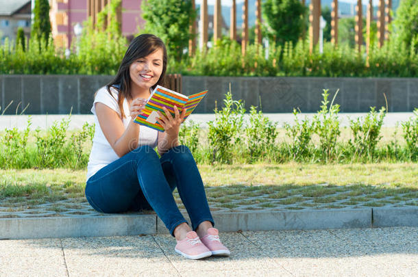 女孩坐下来读笔记本或日记