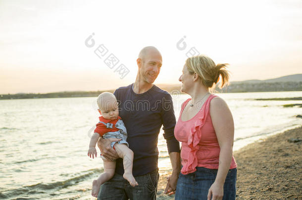 三个人的家庭站在日落和<strong>大海</strong>的<strong>背景</strong>上