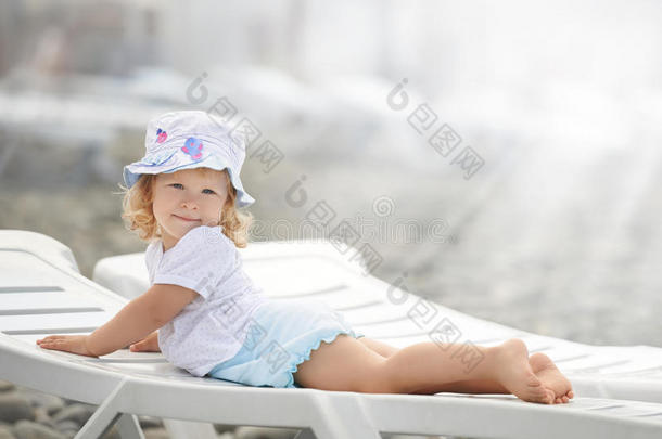 孩子躺在海滩上，在阳光下很久