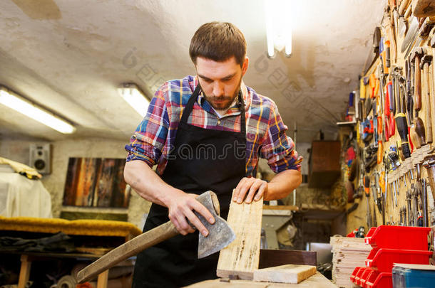 木匠用斧头和木板在车间工作