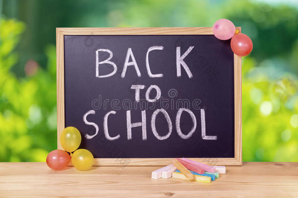 带回学校的课文的教育概念是用黑板、彩色粉笔和气球写在绿色的木桌上