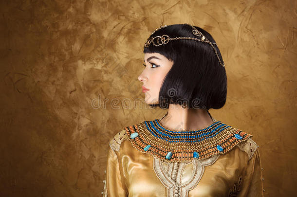 美丽的女人，就像埃及女王克利奥帕特拉的金色背景。 侧视图，面部轮廓