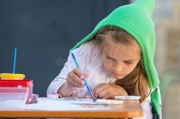 女孩<strong>热情</strong>地画水彩画，坐在院子里的桌子旁