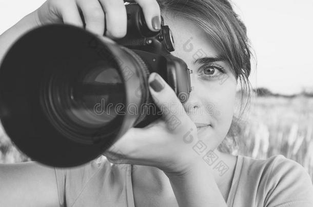 黑白照片的女孩看着相机取景器在相机瞄准自然