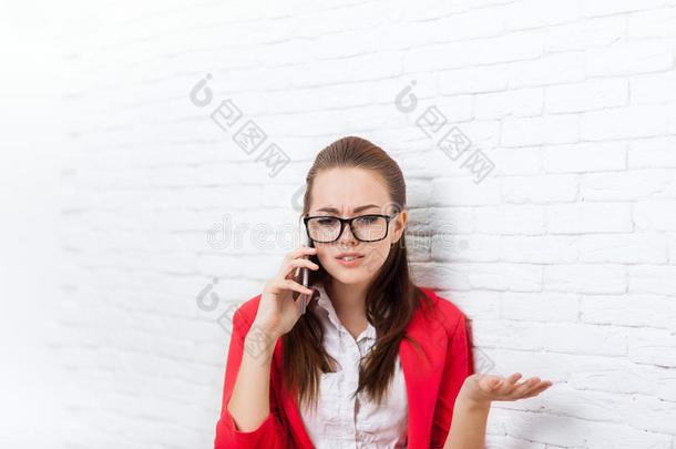 女商人严重的负面手机通话问题戴着红色夹克眼镜在手机上讲话