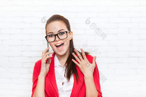 女商人高兴兴奋的手机通话，戴着红色夹克眼镜在手机上交谈