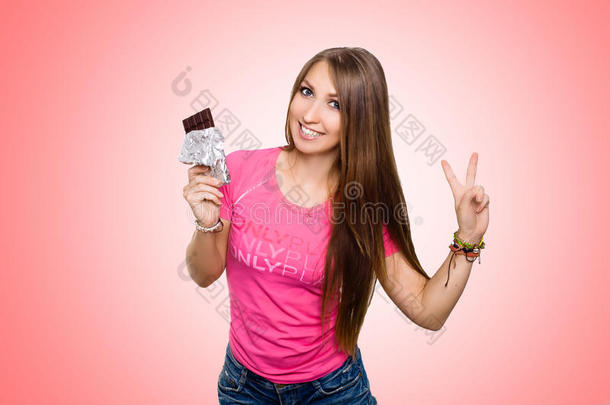 <strong>美女模特</strong>吃黑巧克力。 美丽惊讶的年轻女人吃巧克力糖果，微笑和表演
