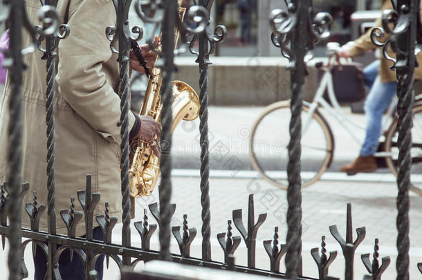 非洲街头音乐家演奏爵士乐在萨克斯管投掷格子与自行<strong>车剪影</strong>，城市生活在阿姆斯特丹
