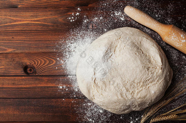 面团与面粉，擀面杖，小麦耳朵在乡村木桌上从上面。 面包或<strong>比萨</strong>饼的自制糕点。 面包店背景