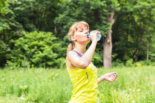 健身美女在夏天炎热的日子锻炼后喝水和出汗