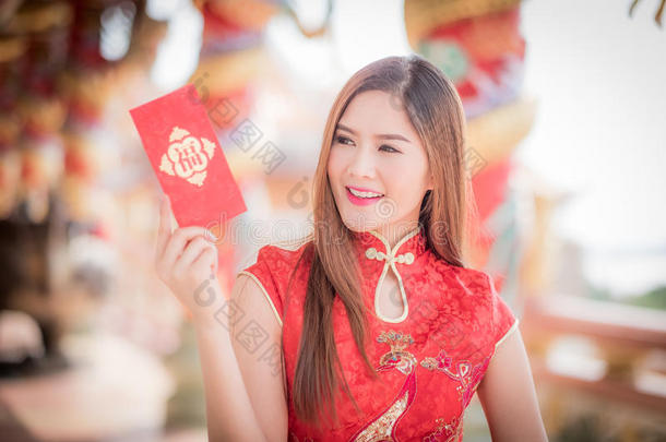 穿着中国服装的亚洲女人拿着对联“快乐”(中文w