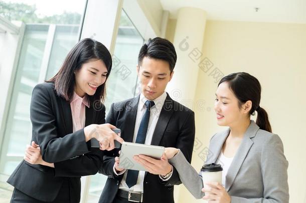 亚洲商业团队在平板电脑上谈论一些事情
