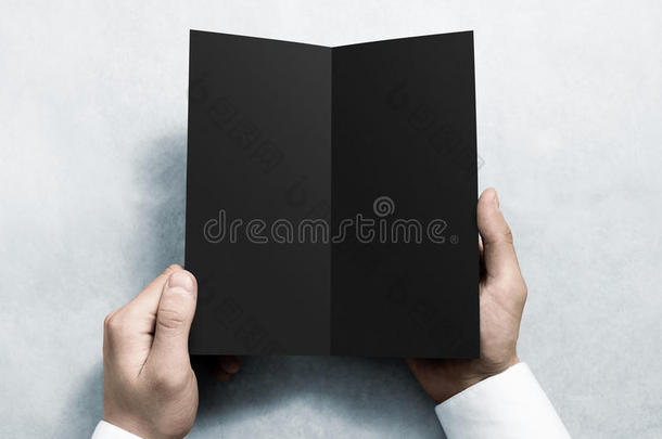 手打开空白黑色传单小册子模型。 小册子介绍。