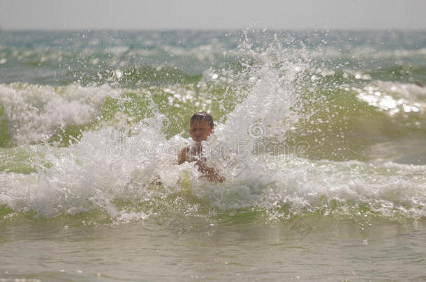 男孩在海里嬉戏，溅起<strong>浪花</strong>