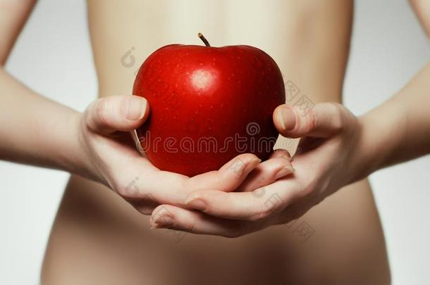 双手捧着红苹果。 持有红色AP的年轻女人的肖像