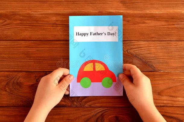 贺卡父亲'；的一天。 孩子手里拿着一张贺卡。 快乐的父亲和#x27；的一天。 轻松的孩子手工艺