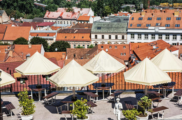 斯洛伐克特伦钦市花园餐厅的空桌、椅子和雨伞