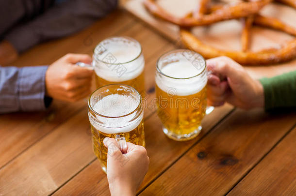 在酒吧或酒吧用啤酒杯把手闭起来