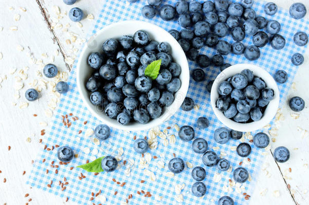 新鲜采摘的蓝莓在白色的碗里。 多汁新鲜的蓝莓。 木背景上的蓝莓