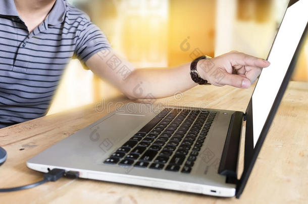 特写年轻的商人指着咖啡店木制桌子上的屏幕笔记本电脑。
