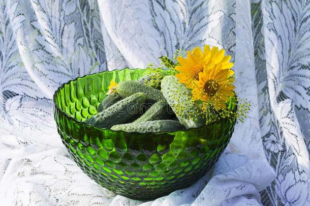 黄瓜放在玻璃绿色花瓶或碗里的背景上