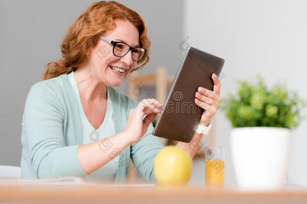 情绪快乐的女人坐着用平板电脑