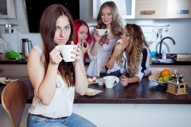 朋友们在厨房喝茶和咖啡，前景是年轻漂亮的黑发女人的肖像，带着白色杯子的女人
