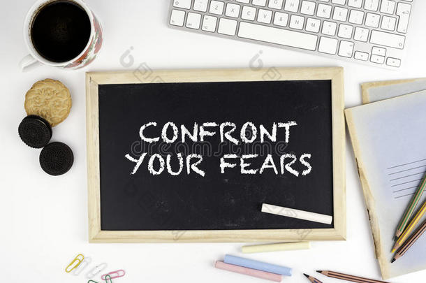 写字台上的黑板上有文字：面对你的恐惧