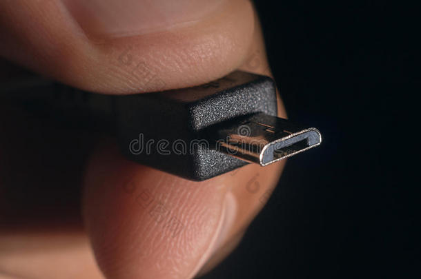 手握黑色<strong>微型</strong>USB电缆。 男人的手拿着USB<strong>微型</strong>连接器。