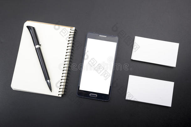 名片空白，智能手机或平板电脑，花和笔在办公桌桌面视图。 公司文具