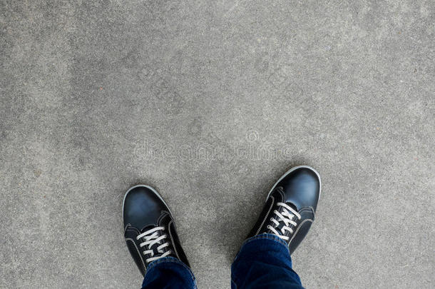 黑色休闲鞋站在混凝土地板上