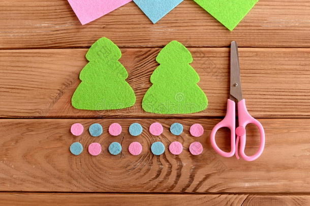 绿色的圣诞树图案，粉红色和蓝色的球，木制背景上的剪刀。 为孩子们上的<strong>硕士</strong>班。 一步