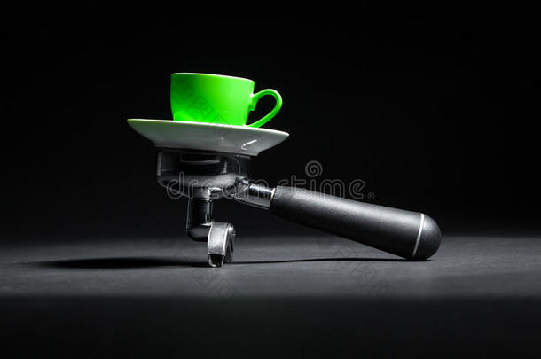 艺术工作室拍摄的持有人咖啡机和绿色杯子；