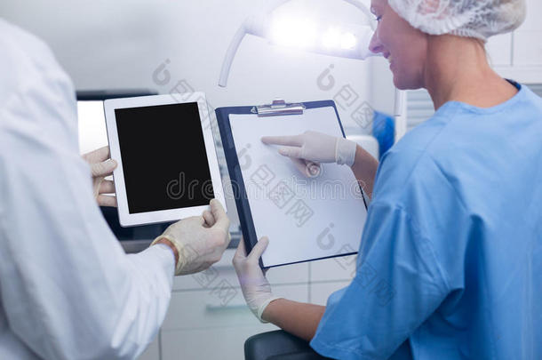 牙科医生和牙科助理在数字平板电脑上工作