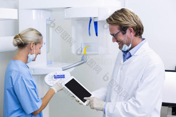 牙科医生和牙科助理在数字平板电脑上工作