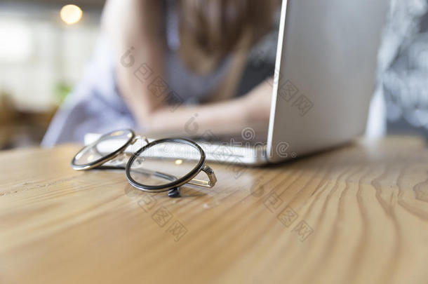 木制桌子上有笔记本电脑笔记本的眼镜