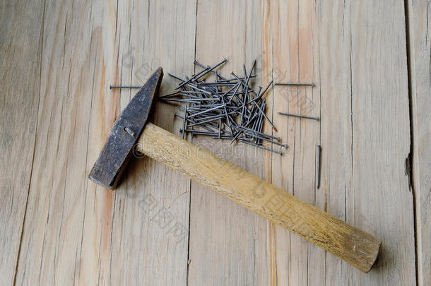 木桌背景上的锤子和钉子