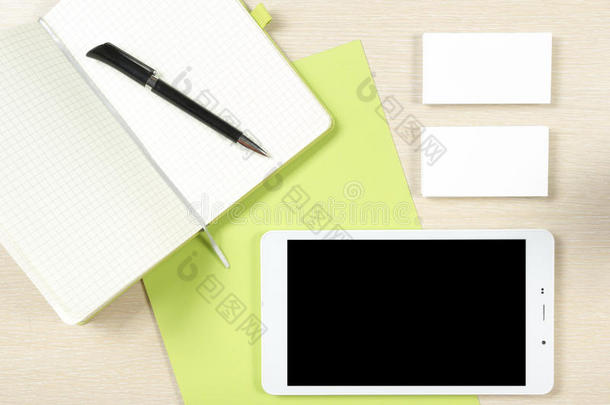 名片空白，智能手机或平板电脑，记事本和钢笔在办公桌桌面视图。 公司文具