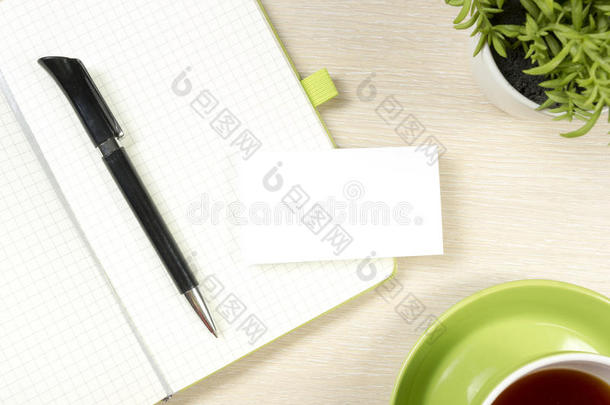 名片空白，记事本，咖啡杯和笔，花在办公桌桌面视图。 公司文具品牌