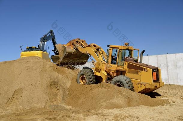 反铲和前端装载机移动沙子