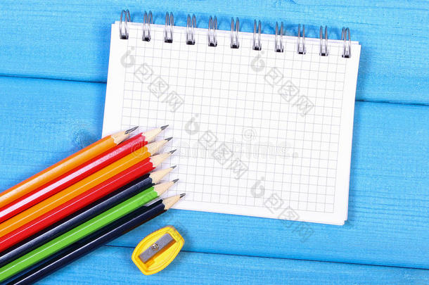 彩色蜡笔，卷笔刀和记事本的蓝色板，学校配件，复制空间的文字