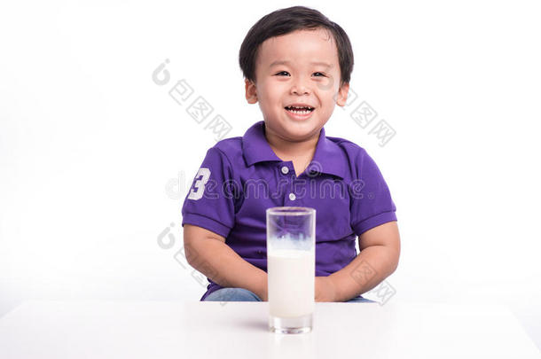 可爱的小男孩喝牛奶，留着牛奶胡子，拿着一杯牛奶